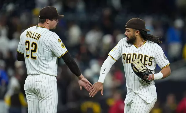 San Diego Padres second baseman Fernando Tatis Jr., right, celebrates with relief pitcher Mason Miller after the Padres defeated the Chicago Cubs 9-7 in a baseball game Monday, April 27, 2026, in San Diego. (AP Photo/Gregory Bull)