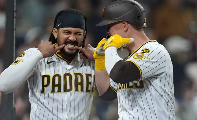 San Diego Padres' Gavin Sheets, right, celebrates his home run with teammate Fernando Tatis Jr. during the eighth inning of a baseball game against the Chicago Cubs Monday, April 27, 2026, in San Diego. (AP Photo/Gregory Bull)