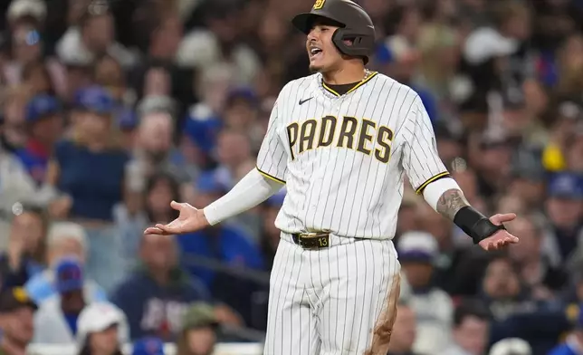San Diego Padres' Manny Machado gestures while standing on third base during the fifth inning of a baseball game against the Chicago Cubs Monday, April 27, 2026, in San Diego. (AP Photo/Gregory Bull)