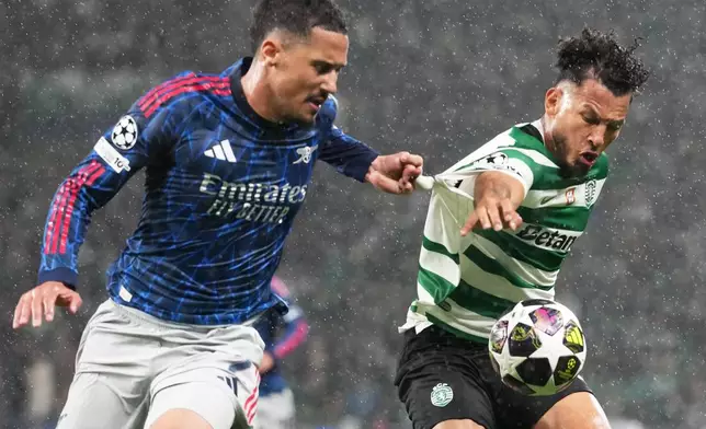 Arsenal's William Saliba, left, challenges Sporting's Luis Suarez during the Champions League quarterfinals, first leg, soccer match between Sporting CP and Arsenal, in Lisbon, Tuesday, April 7, 2026. (AP Photo/Armando Franca)