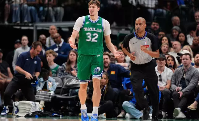 Dallas Mavericks forward Cooper Flagg (32) reacts to play as referee Sean Corbin, right, jogs upcourt in the second half of an NBA basketball game against the Orlando Magic Friday, April 3, 2026, in Dallas. (AP Photo/Tony Gutierrez)