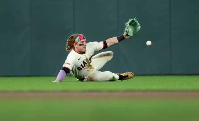 San Francisco Giants' Harrison Bader dives for a single hit by Philadelphia Phillies' Trea Turner during the seventh inning of a baseball game in San Francisco, Monday, April 6, 2026. (AP Photo/Jed Jacobsohn)