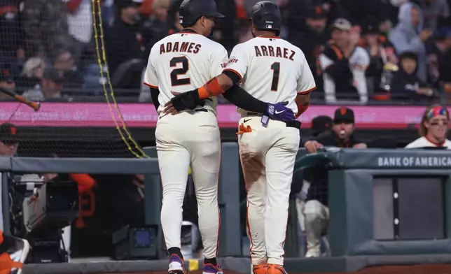 San Francisco Giants' Luis Arraez (1) and Willy Adames (2) celebrate after scoring on a two-run triple hit by Matt Chapman during the third inning of a baseball game against the Philadelphia Phillies in San Francisco, Monday, April 6, 2026. (AP Photo/Jed Jacobsohn)