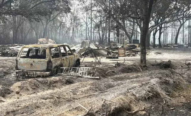 This photo provided by the Georgia Department of Natural Resources shows burned vehicles and trees from the Pineland Road Fire in southeast Georgia on Wednesday, April 22, 2026. (Georgia Department of Natural Resources via AP)