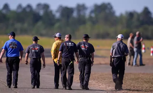 Fire crews and truck assemble at the Brantley County Airport as they work the Brantley highway 82 fire, Thursday, April 23, 2026, near Nahunta, Ga. (AP Photo/Mike Stewart)