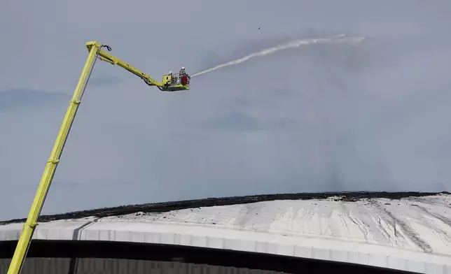 Firefighters work to control a fire on the roof of Rio de Janeiro's Olympic Park velodrome, Wednesday, April 8, 2026. (AP Photo/Bruna Prado)