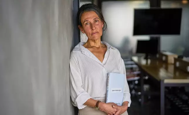 Rachel Goldberg-Polin, whose 23-year-old son, Hersh, was kidnapped on Oct. 7, 2023 Hamas cross border attack on Israel and killed in Gaza nearly a year later, poses for a photo with her new book "When We See You Again," in Jerusalem, Wednesday, April 15, 2026. (AP Photo/Ohad Zwigenberg)