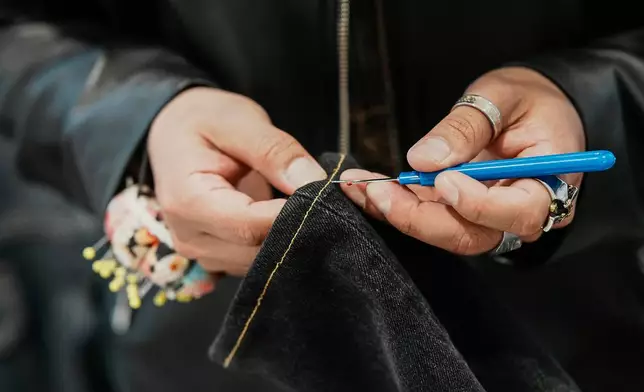 Tailor Marco Lema, 35, of Ecuador, works on a denim alteration at Nordstrom headquarters in New York, Monday, March 23, 2026. (AP Photo/Eduardo Munoz Alvarez)