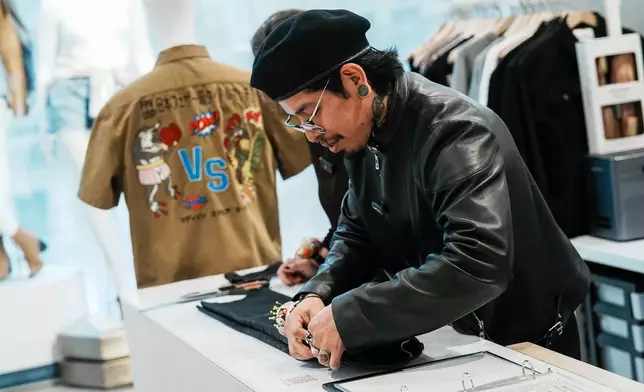Tailor Marco Lema, 35, of Ecuador, works on a denim alteration at Nordstrom headquarters in New York, Monday, March 23, 2026. (AP Photo/Eduardo Munoz Alvarez)