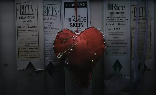 A heart-shaped pincushion bristling with needles hangs on the wall inside Kil Bae's store on Friday, March 27, 2026, in New York. (AP Photo/Andres Kudacki)
