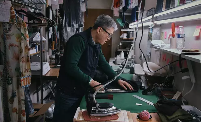 Tailor, Kil Bae, works inside his shop on Friday, March 27, 2026, in New York. (AP Photo/Andres Kudacki)