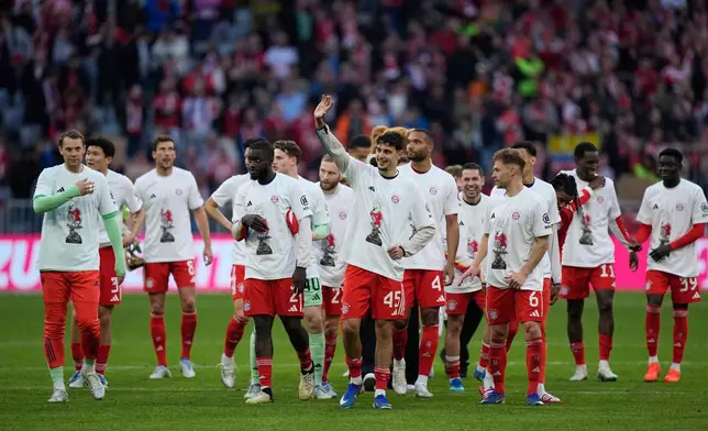 Bayern players celebrate after their team clinched the German league title after a Bundesliga soccer match between Bayern and Stuttgart in Munich, Germany, Sunday, April 19, 2026. (AP Photo/Matthias Schrader)