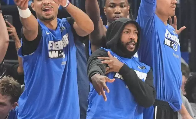 Orlando Magic players, from left, Jett Howard, Jamal Cain, Jase Richardson and Tristan da Silva cheer on their team after a 3-point basket against the Detroit Pistons during the first half in Game 3 of a first-round NBA basketball playoff series, Saturday, April 25, 2026, in Orlando, Fla. (AP Photo/John Raoux)