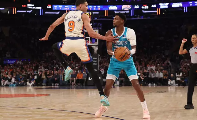 Charlotte Hornets' Brandon Miller, front right, looks to pass the ball against New York Knicks' Kevin McCullar Jr. (9) during the first half of an NBA basketball game Sunday, April 12, 2026, in New York. (AP Photo/Pamela Smith)