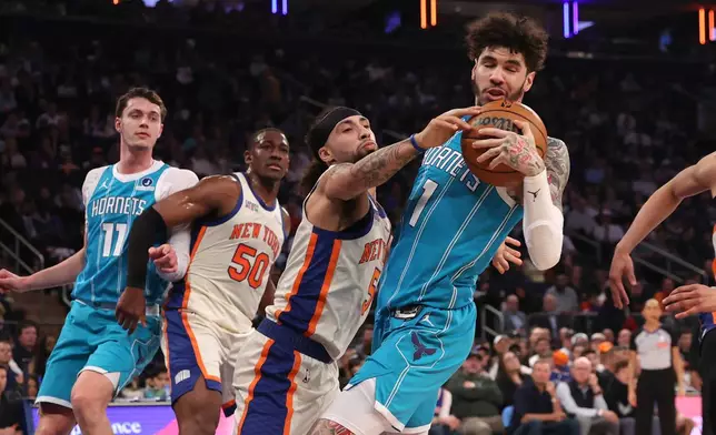 New York Knicks' Jose Alvarado (5) attempts to steal the ball from Charlotte Hornets' LaMelo Ball (1) during the first half of an NBA basketball game Sunday, April 12, 2026, in New York. (AP Photo/Pamela Smith)