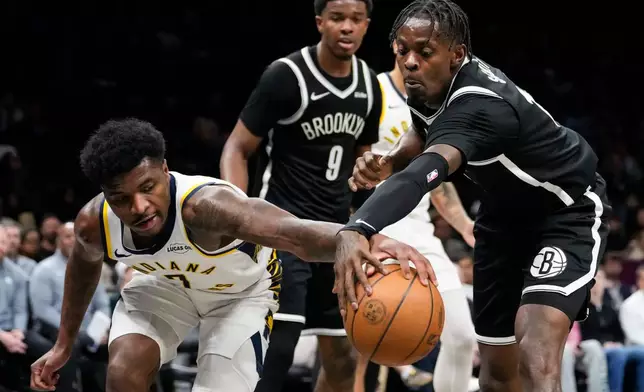 Indiana Pacers guard Kam Jones (7) fights for control of the ball with Brooklyn Nets forward Trevon Scott (13) during the first half of an NBA basketball game, Thursday, April 9, 2026, in New York. (AP Photo/Yuki Iwamura)
