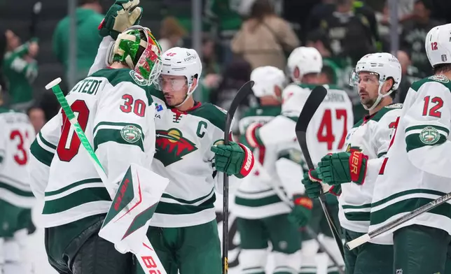 Minnesota Wild goaltender Jesper Wallstedt (30) reacts with defenseman Jared Spurgeon (46) after their team defeated the Dallas Stars 4-2 in Game 5 of a first-round NHL Stanley Cup playoffs hockey series, Tuesday, April 28, 2026, in Dallas. (AP Photo/Julio Cortez)