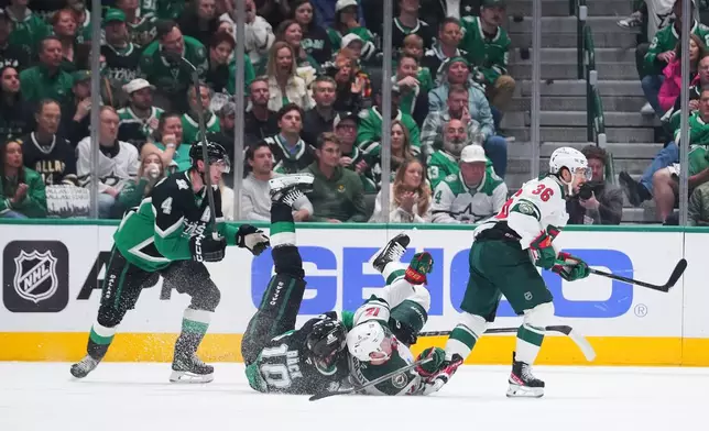 Dallas Stars center Oskar Bäck (10) collides with Minnesota Wild left wing Matt Boldy (12) as Stars' defenseman Miro Heiskanen (4) and Wild right wing Mats Zuccarello (36) eye the puck during the first period in Game 5 of a first-round NHL Stanley Cup playoffs hockey series, Tuesday, April 28, 2026, in Dallas. (AP Photo/Julio Cortez)