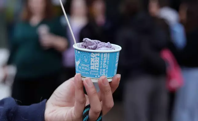 Bettina Guevara holds her free serving of ice cream outside the Ben and Jerry's scoop shop on Free Cone Day in Burlington, Vt., Tuesday, April 14, 2026. (AP Photo/Amanda Swinhart)