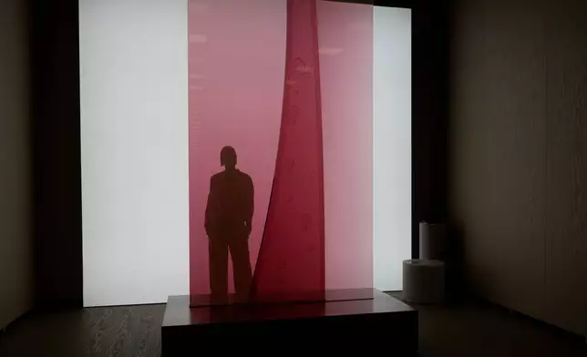 Designer Sabine Marcelis poses behind her creation 'Plume' a liquid sculpture displayed at the Salone Raritas, collectible design pavilion, during the Milan Design Week, in Rho, Italy, Tuesday, April 21, 2026. (AP Photo/Luca Bruno)