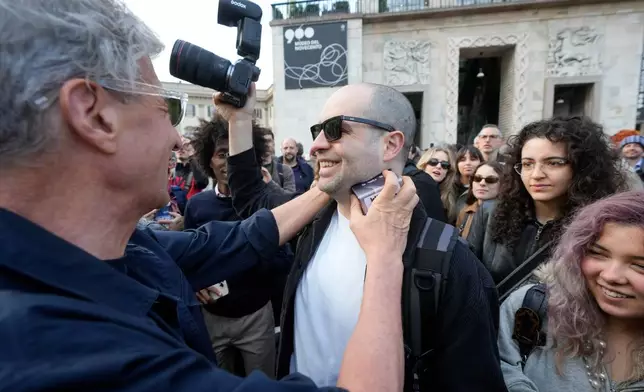 Artist Maurizio Cattelan participates in the objects changing event 'Barter breakfast' in front of the Duomo gothic cathedral, in Milan, Italy, Monday, April 20, 2026. (AP Photo/Luca Bruno)