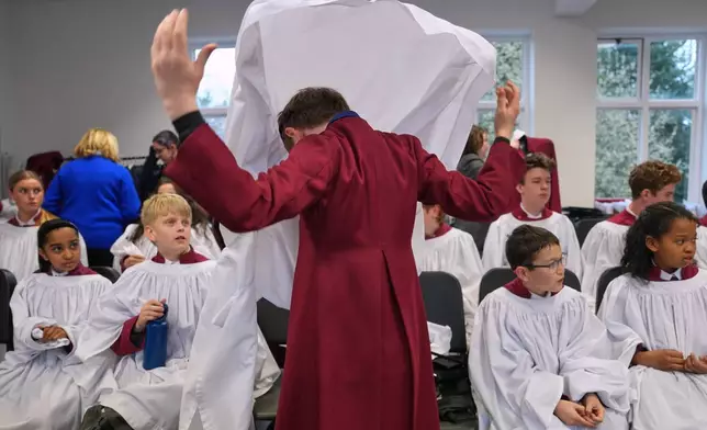 Britain Choral Music Choristers put on their garments for Evensong at Rochester Cathedral in Rochester, England, Friday, March 27, 2026. (AP Photo/Kin Cheung)