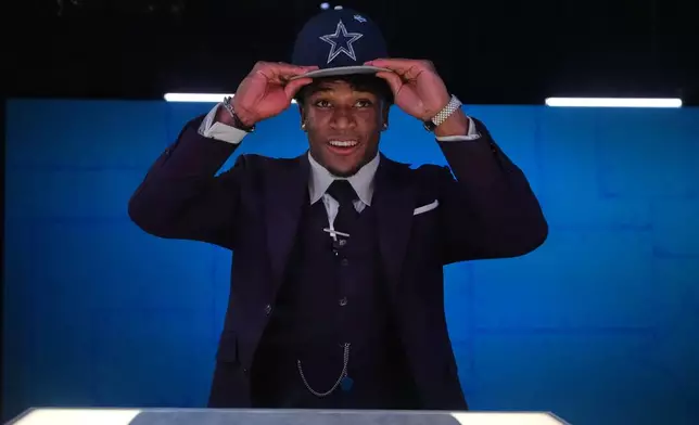 Ohio State defensive back Caleb Downs puts on a hat after being chosen by the Dallas Cowboys with the 11th overall pick during the first round of the NFL football draft, Thursday, April 23, 2026, in Pittsburgh. (AP Photo/Jeff Roberson)