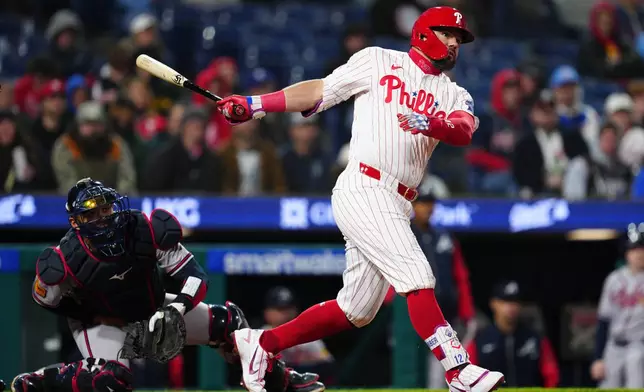 Philadelphia Phillies' Kyle Schwarber, right, watches his double off Atlanta Braves pitcher Aaron Bummer during the fifth inning of a baseball game, Sunday, April 19, 2026, in Philadelphia. (AP Photo/Derik Hamilton)