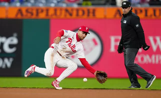 Philadelphia Phillies' Trea Turner, left, fields a groundout hit by Atlanta Braves' Austin Riley during the fourth inning of a baseball game, Sunday, April 19, 2026, in Philadelphia. (AP Photo/Derik Hamilton)