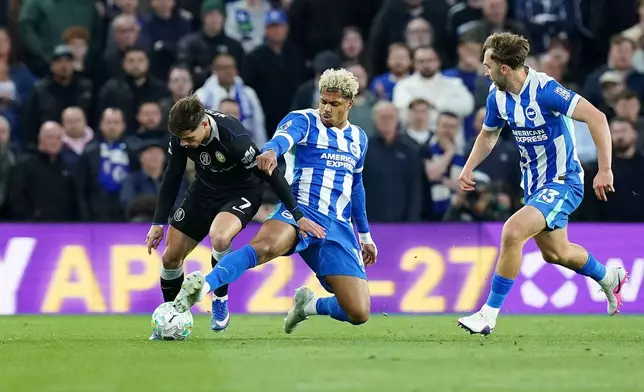 Chelsea's Pedro Neto, left, is tackled by Brighton and Hove Albion's Georginio Rutter during the English Premier League soccer match between Brighton &amp; Hove Albion and Chelsea in Brighton, England, Tuesday, April 21, 2026. (Gareth Fuller/PA via AP)