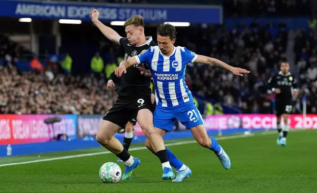 Chelsea's Liam Delap, left, and Brighton and Hove Albion's Olivier Boscagli battle for the ball during the English Premier League soccer match between Brighton &amp; Hove Albion and Chelsea in Brighton, England, Tuesday, April 21, 2026. (Gareth Fuller/PA via AP)