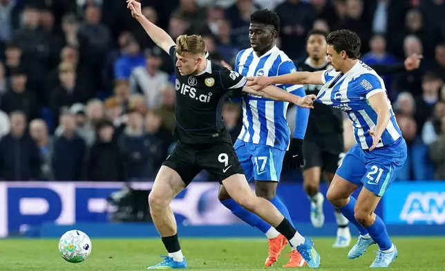Chelsea's Liam Delap, left, and Brighton and Hove Albion's Olivier Boscagli battle for the ball during the English Premier League soccer match between Brighton &amp; Hove Albion and Chelsea in Brighton, England, Tuesday, April 21, 2026. (Gareth Fuller/PA via AP)