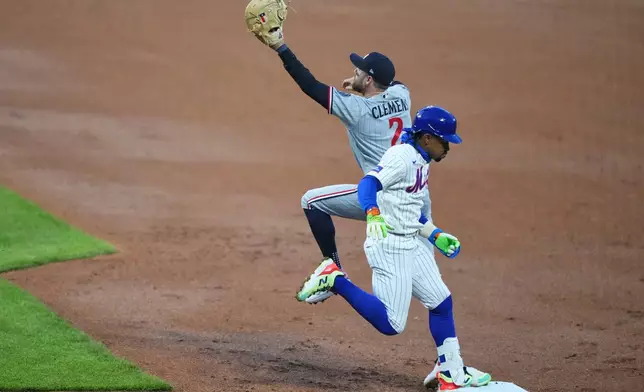 New York Mets' Francisco Lindor (12) runs past Minnesota Twins' Kody Clemens (2) to reach first base for a single during the first inning of a baseball game Wednesday, April 22, 2026, in New York. (AP Photo/Frank Franklin II)