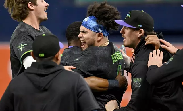 Tampa Bay Rays celebrate after Jonathan Aranda's, center, RBI walk-off single during the tenth inning of a baseball game against the New York Yankees Saturday, April 11, 2026, in St. Petersburg, Fla. (AP Photo/Jason Behnken)