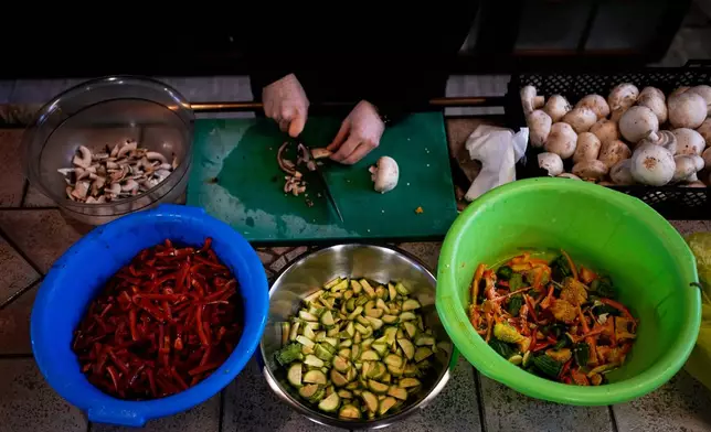 A monk prepares meals at the Monastery of St. Augustine and Seraphim of Sarov ahead of Easter as part of annual Lenten dietary restrictions in the village of Trikorfo, about 236 kilometers (147 miles) northwest of Athens, Friday, March 20, 2026. (AP Photo/Thanassis Stavrakis)