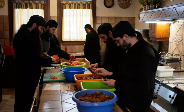 Monks prepare the meals at the Monastery of St. Augustine and Seraphim of Sarov in the village of Trikorfo, about 236 kilometers (147 miles) northwest of Athens, Friday, March 20, 2026. (AP Photo/Thanassis Stavrakis)