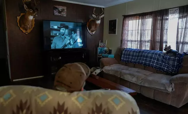 Retired railroad worker and Army veteran Charles "Duke" Hodge watches old Westerns with Sophie, one of his two Yorkies, in his home at the Olde Oak RV Park and Campground where he lives and works in West Columbia, W.Va., Tuesday, March 17, 2026. (AP Photo/Carolyn Kaster)