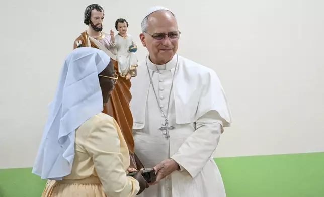 Pope Leo XIV receives a gift during his visit to the Ngul Zamba (Power of God) orphanage in Yaounde, Cameroon, Wednesday April 15, 2026 on the third day of his apostolic journey to Africa. (Alberto Pizzoli, Pool Photo via AP)