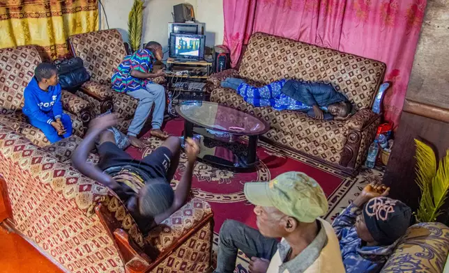 Caro Bih's family watches television in their living room in Bamenda, Cameroon, Monday, April 13, 2026. (AP Photo/Welba Yamo Pascal)