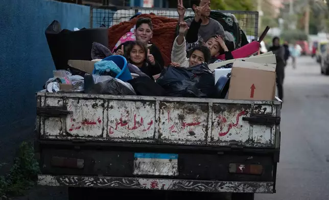 Displaced children sit on a truck with their packed belongings as they wait for an official ceasefire decision between Iran and the United States that they hope will include Lebanon and allow them to return to their villages, in the southern port city of Sidon, Lebanon, Wednesday, April 8, 2026. (AP Photo/Mohammed Zaatari)