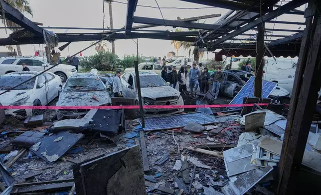People check the damage of a coffeeshop at the site of an Israeli strike in the southern port city of Sidon, Lebanon, Wednesday, April, 8, 2026. (AP Photo/Mohammed Zaatari)
