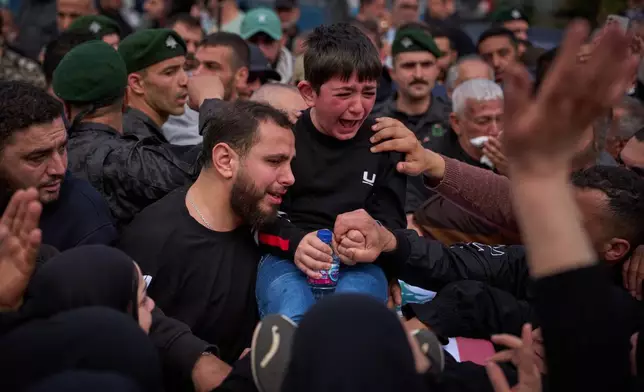 Mohammed, 8, weeps next to the coffin of his father, Hussein Makkah, during the funeral of 13 state security officers killed the previous day in an Israeli strike in Lebanon’s coastal city of Sidon, Lebanon, Saturday, April 11, 2026. (AP Photo/Emilio Morenatti)