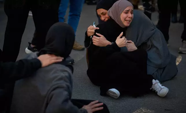 Mourners react during the funeral of 13 state security officers killed the previous day in an Israeli strike in Lebanon's coastal city of Sidon, Saturday, April 11, 2026. (AP Photo/Emilio Morenatti)