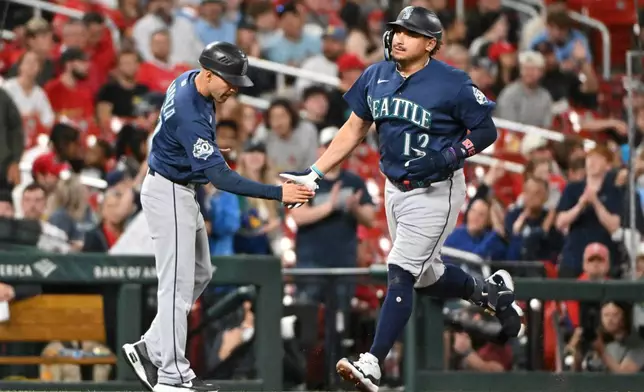 Seattle Mariners' Josh Naylor, right, is congratulated by third base coach Carlos Cardoza after hitting a home run against the St. Louis Cardinals during the sixth inning of a baseball game, Friday, April 24, 2026, in St. Louis. (AP Photo/Jeff Le)