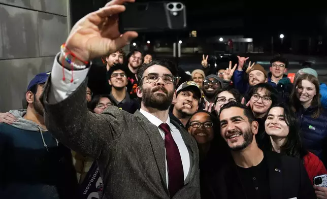 Streamer Hasan Piker, left, and Abdul El-Sayed, a progressive candidate in the Democratic primary for U.S. Senate in Michigan, center right, take a selfie with young fans following a campaign event, Tuesday, April 7, 2026, at the University of Michigan in Ann Arbor, Mich. (AP Photo/Julia Demaree Nikhinson)