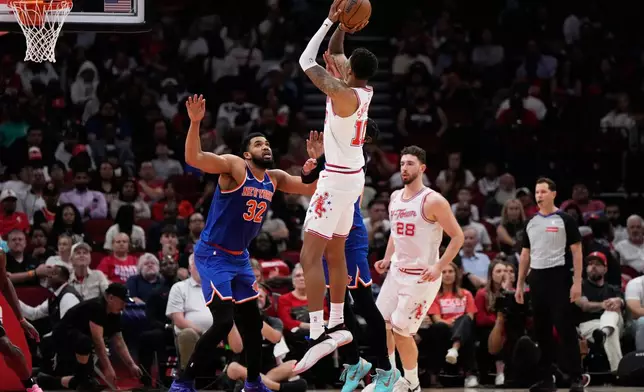 Houston Rockets forward Jabari Smith Jr. (10) shoots against New York Knicks center Karl-Anthony Towns (32) during the first half of an NBA basketball game in Houston, Tuesday, March 31, 2026. (AP Photo/Ashley Landis)