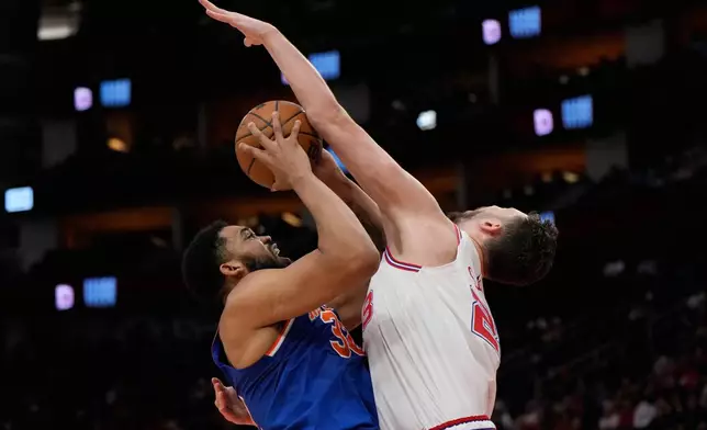 Houston Rockets center Alperen Sengun fouls New York Knicks center Karl-Anthony Towns (32) during the first half of an NBA basketball game in Houston, Tuesday, March 31, 2026. (AP Photo/Ashley Landis)