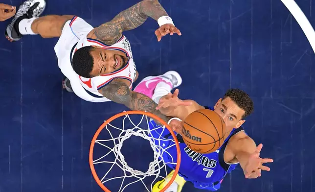 Los Angeles Clippers forward John Collins, left, and Dallas Mavericks forward Dwight Powell reach for a rebound during the first half of an NBA basketball game Tuesday, April 7, 2026, in Inglewood, Calif. (AP Photo/Mark J. Terrill)