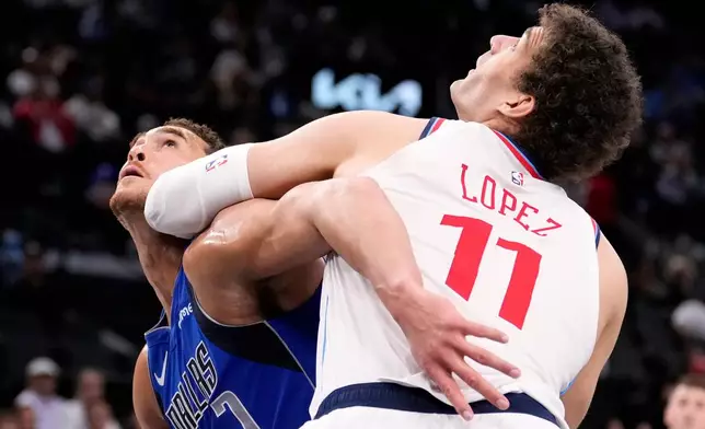 Dallas Mavericks forward Dwight Powell, left, and Los Angeles Clippers center Brook Lopez battle for a rebound during the first half of an NBA basketball game Tuesday, April 7, 2026, in Inglewood, Calif. (AP Photo/Mark J. Terrill)