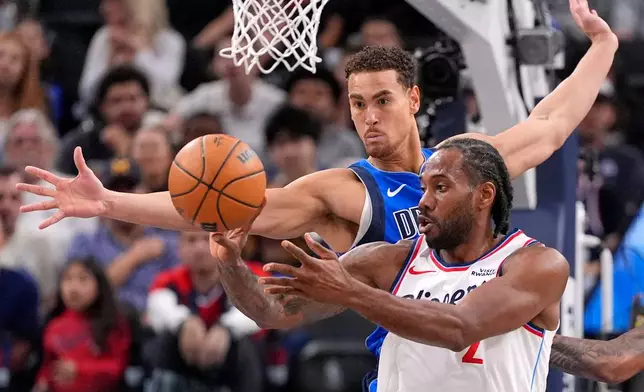 Los Angeles Clippers forward Kawhi Leonard, right, passes the ball as Dallas Mavericks forward Dwight Powell defends during the first half of an NBA basketball game Tuesday, April 7, 2026, in Inglewood, Calif. (AP Photo/Mark J. Terrill)